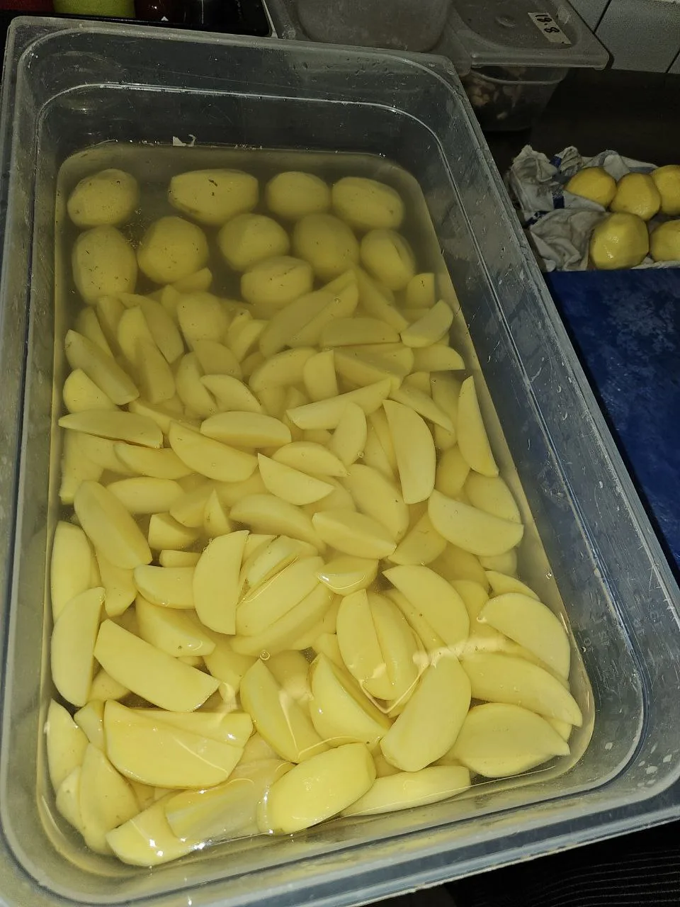 Pommes de terre coupées à la main dans l'eau avant friture